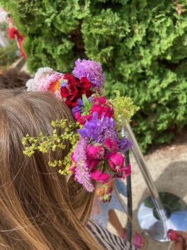 couronne de fleurs fraiches et sèches sur la tête d'une petite fille de dos