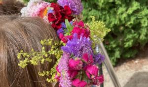 couronne de fleurs fraiches et sèches sur la tête d'une petite fille de dos