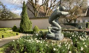 Herakles en bronze de profil entouré de fleurs de narcisses