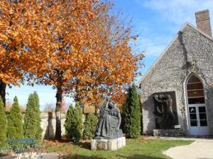 sculpture de Sapho devant des arbres flamboyants