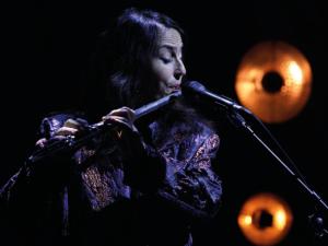 flutiste dans la pénombre devant un micro