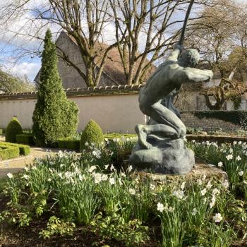 Herakles en bronze de profil entouré de fleurs de narcisses