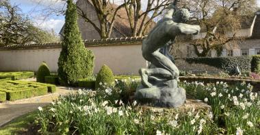 Herakles en bronze de profil entouré de fleurs de narcisses