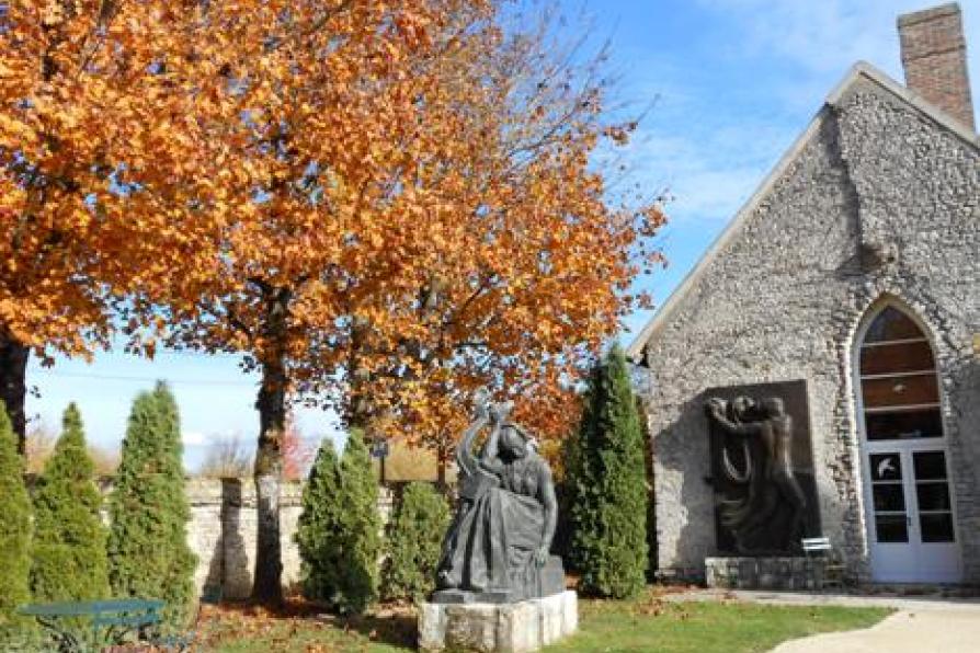 sculpture de Sapho devant des arbres flamboyants